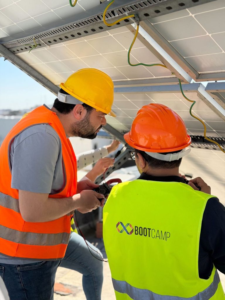 Formation photovoltaïque agréée ANME : stagiaires installant des panneaux solaires sur la plateforme BOOTCAMP