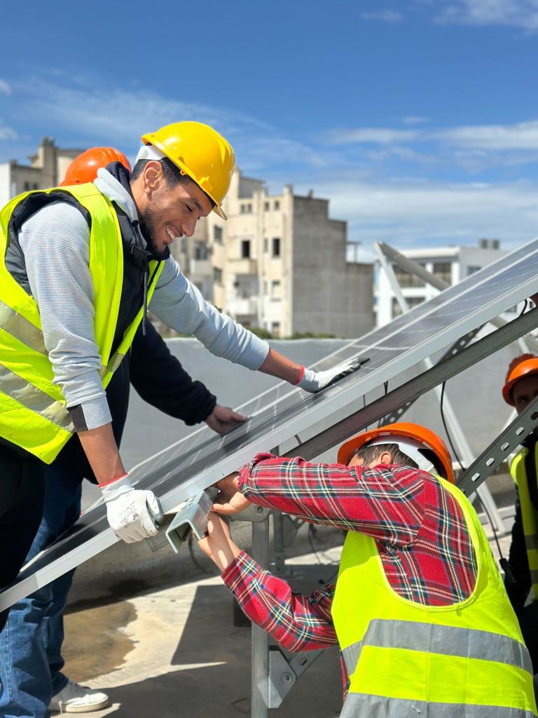 Formation photovoltaïque agréée ANME : stagiaires installant des panneaux solaires sur la plateforme BOOTCAMP