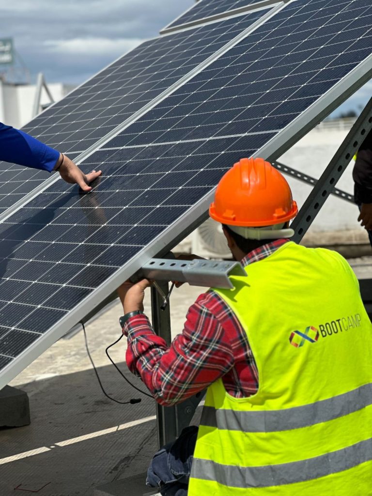 Formation photovoltaïque agréée ANME : stagiaires installant des panneaux solaires sur la plateforme BOOTCAMP