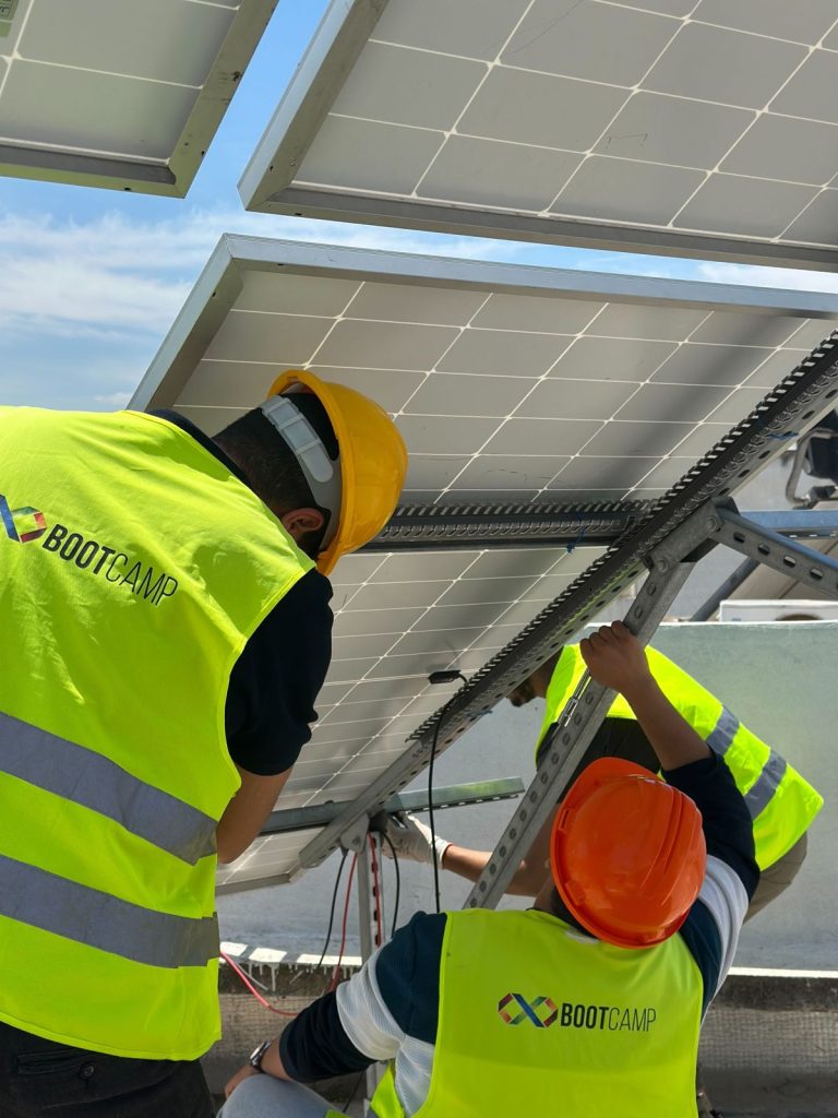 Formation photovoltaïque agréée ANME : stagiaires installant des panneaux solaires sur la plateforme BOOTCAMP