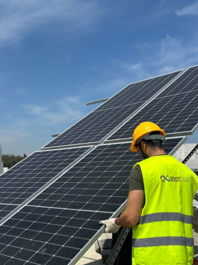 Formation photovoltaïque agréée ANME : stagiaires installant des panneaux solaires sur la plateforme BOOTCAMP