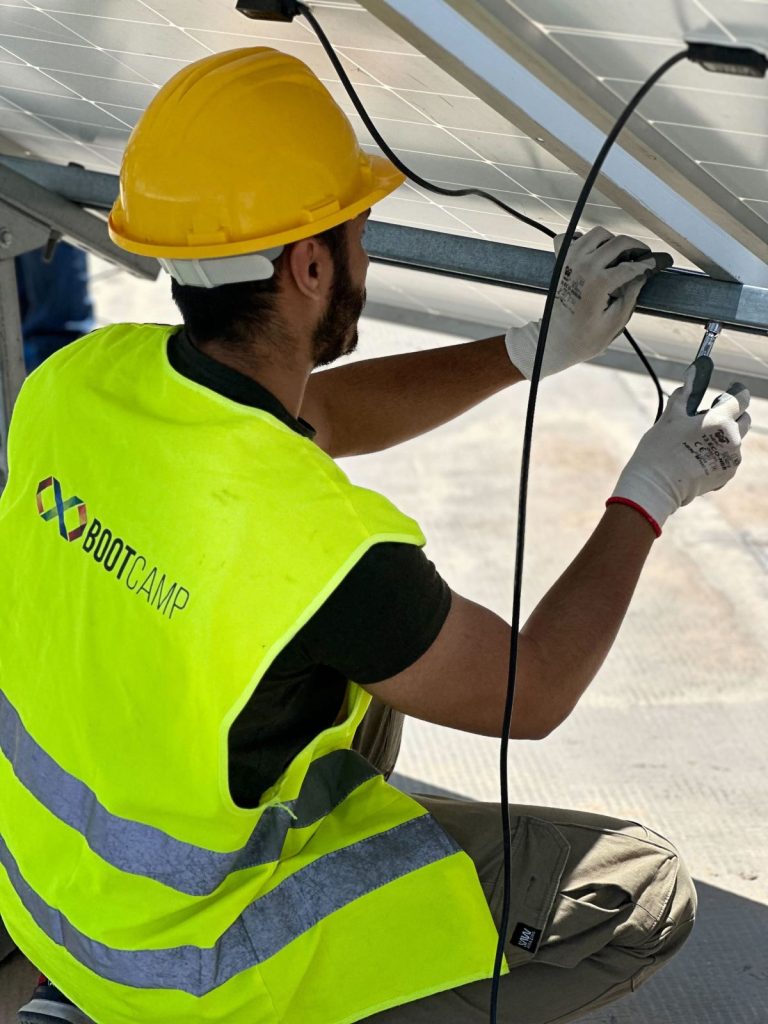 Formation photovoltaïque agréée ANME : stagiaires installant des panneaux solaires sur la plateforme BOOTCAMP